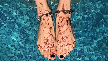 Sexy painted henna feet swim in the pool